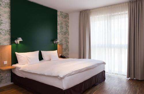 Una cama o camas en una habitación de Grimms Hotel Hanau