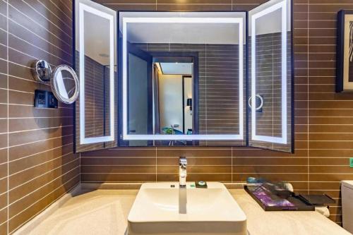 a bathroom with a sink and a mirror at Xana Hotelle·Taiyuan South Inner Ring in Taiyuan