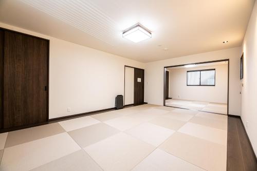 an empty room with a door and a tiled floor at Irodori Hotel AKEBONO in Fukuoka