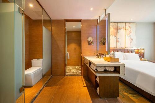 a bathroom with a bed and a shower and a sink at James Joyce Coffetel Chengdou Wuqing Wanda Plaza in Chengdu