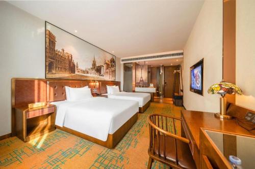 a hotel room with two beds and a desk at James Joyce Coffetel Chengdou Wuqing Wanda Plaza in Chengdu