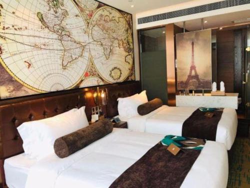 three beds in a room with a map on the wall at James Joyce Coffetel Chengdou Wuqing Wanda Plaza in Chengdu