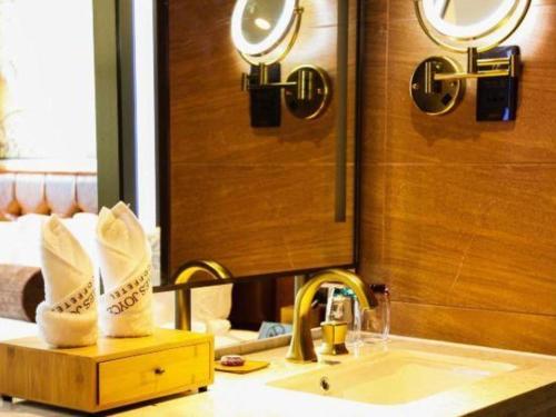 a bathroom with a sink and a mirror at James Joyce Coffetel Chengdou Wuqing Wanda Plaza in Chengdu