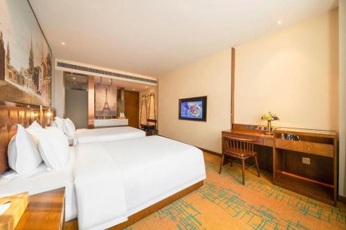 a bedroom with a large white bed and a desk at James Joyce Coffetel Chengdou Wuqing Wanda Plaza in Chengdu