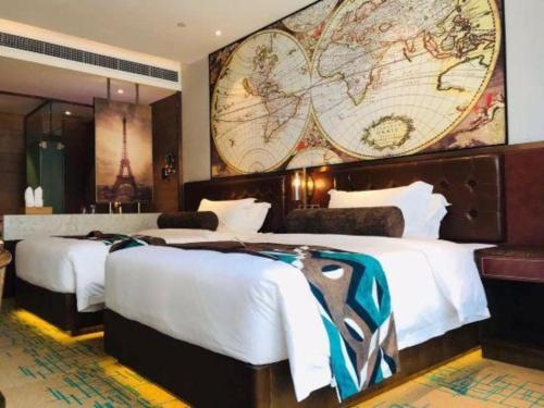 two beds in a hotel room with a large map on the wall at James Joyce Coffetel Chengdou Wuqing Wanda Plaza in Chengdu