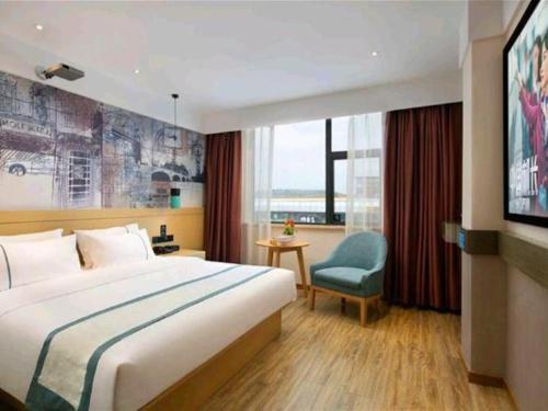 a hotel room with a bed and a tv at City Comfort Inn Ji'an South Administrative Center in Ji'an