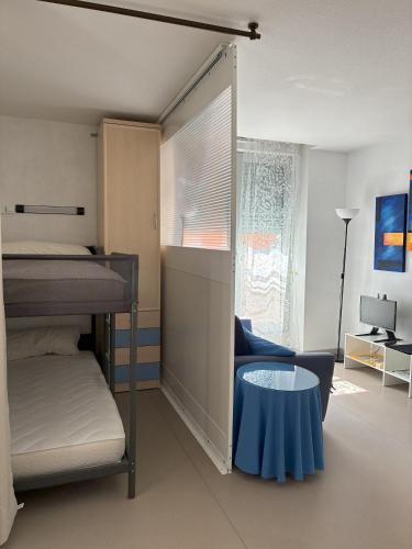 une chambre avec deux lits superposés et une table dans l'établissement APARTAMENTO GEORGE V T2 plus Alcôbe, à Cauterets