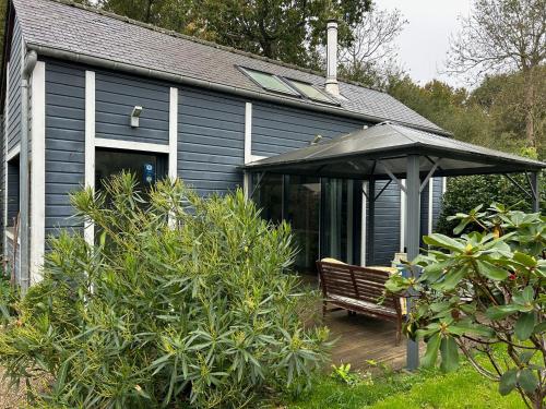a blue house with a bench and an umbrella at Gîte Bambou in Saint-Lunaire