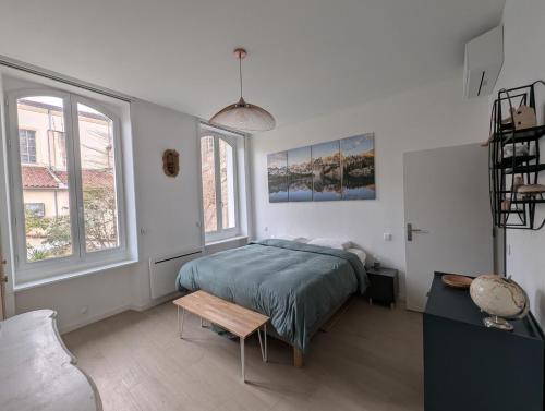 une chambre avec un lit, une table et des fenêtres dans l'établissement 2BR with quiet terrace in the city center, à Marseille