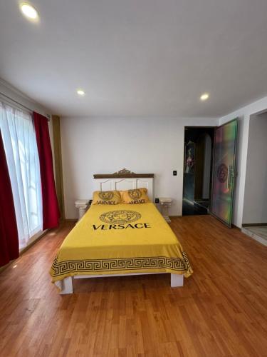 a bedroom with a yellow bed in a room with wooden floors at HOTEL PERSEO - Suites elegantes por noche o 5 horas in Mexico City