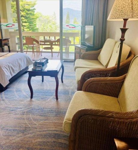 a hotel room with a bed and a coffee table at Kunming Dianchi Garden Hotel & Spa in Kunming