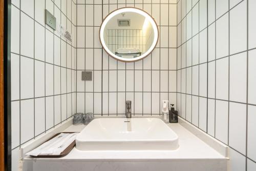 a white bathroom with a sink and a mirror at Xihe Hotel-Shanghai Lujiazui Lancun Road Subway Station Branch in Shanghai