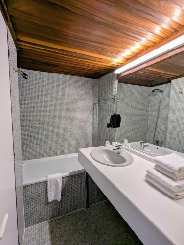 a bathroom with a sink and a bath tub at Gergovia in Super Besse