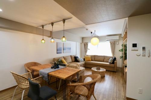 Una sala de estar con una mesa y sillas y un sofá. en Kandaminium Odori, en Ōdōri