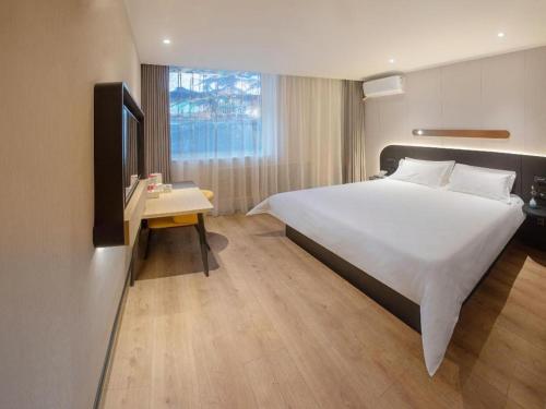 a hotel room with a large bed and a television at Jinjiang Inn Tianshui Chunfeng Road Wanda Plaza in Tianshui