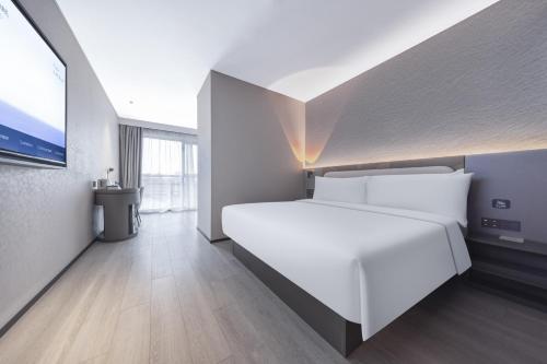 a bedroom with a white bed and a large window at Atour Light Hotel Beijing West Railway Station Liuliqiao Subway Station in Beijing