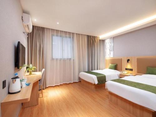 a hotel room with two beds and a television at GreenTree Inn Shanghai Jiading Anting Motor City Express Hotel in Shanghai