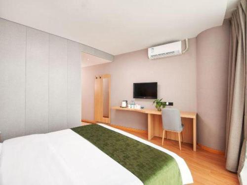 a bedroom with a bed and a desk with a television at GreenTree Inn Shanghai Jiading Anting Motor City Express Hotel in Shanghai