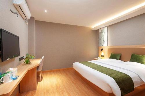 a bedroom with a large bed and a television at GreenTree Inn Shanghai Jiading Anting Motor City Express Hotel in Shanghai