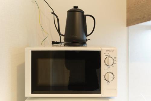 a coffee pot sitting on top of a microwave at Cure Skytree in Tokyo