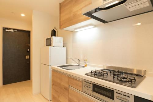 a kitchen with a sink and a white refrigerator at Cure Skytree in Tokyo