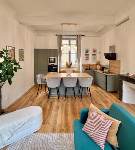 une cuisine et un salon avec une table et des chaises dans l'établissement Luxueux appartement cosy, hypercentre Castres, à Castres
