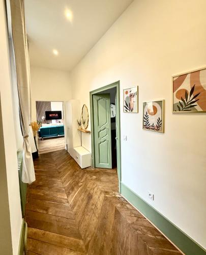 - un couloir avec une porte verte et du parquet dans l'établissement Luxueux appartement cosy, hypercentre Castres, à Castres