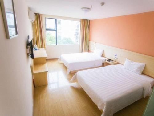 a hotel room with two beds and a window at 7 Days Inn Yiyang Shengli Road in Shangrao