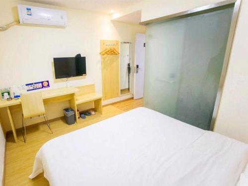 a bedroom with a bed and a desk and a television at 7 Days Inn Yiyang Shengli Road in Shangrao