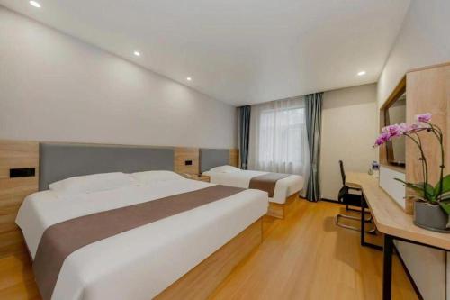 a hotel room with two beds and a desk at GreenTree Inn Nanjing Confucius Temple Sanshan Street Subway Station Express Hotel in Nanjing