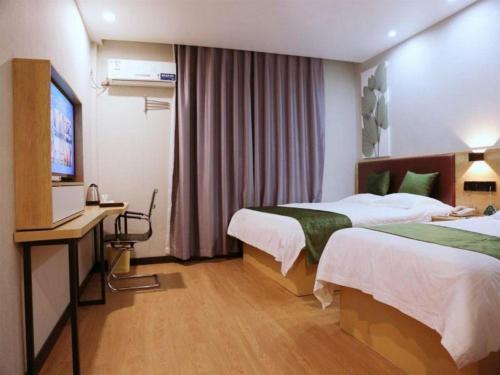 a hotel room with two beds and a television at GreenTree Inn Nanjing Confucius Temple Sanshan Street Subway Station Express Hotel in Nanjing