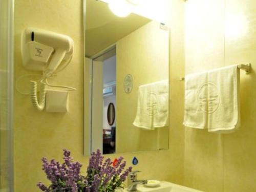 a bathroom with a sink and a mirror and towels at GreenTree Inn Linxi International Convention Center Express Hotel in Linyi