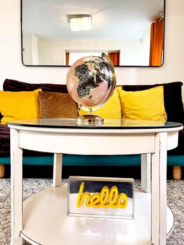 a table with a hello sign and a globe on it at Sunny Suite by Leslodgespa - Studio moderne et coloré, proche de Bâle et de l'aéroport in Blotzheim