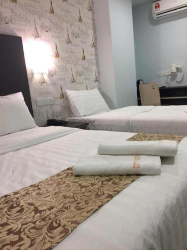 two beds in a hotel room with towels on them at City View Hotel At KLIA & KLIA2 in Kuala Lumpur