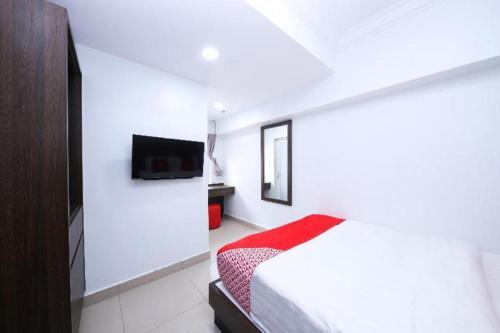 a white room with a bed and a television at Capital O 89538 Ocean Hotel in Labuan
