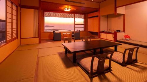 a room with a table and chairs and a dining room at Hotel AreaOne Banjinmisaki in Kashiwazaki