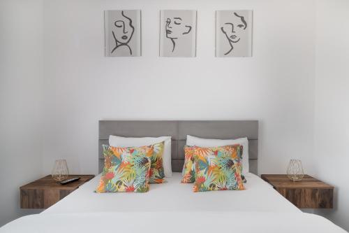 a bedroom with a white bed with two pillows at Golden Hour Apartment in Baile Felix