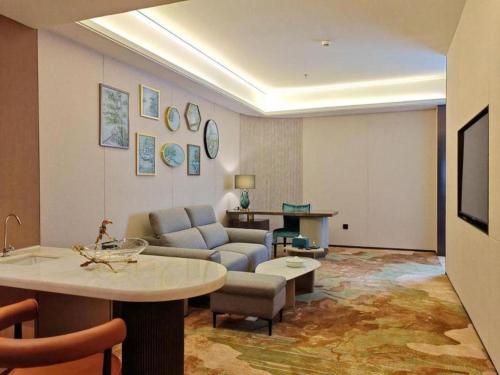 a living room with a couch and a table at Chaozhou Hotel in Chaozhou