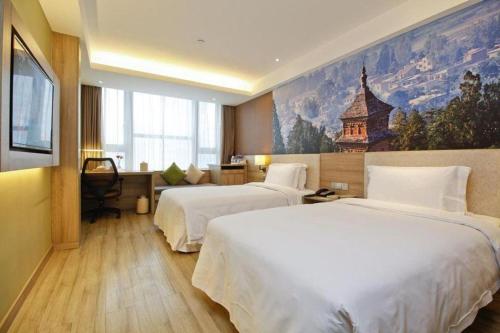 a hotel room with two beds and a painting on the wall at Atour Hotel Xi'an High Tech Dazhai Road in Xi'an