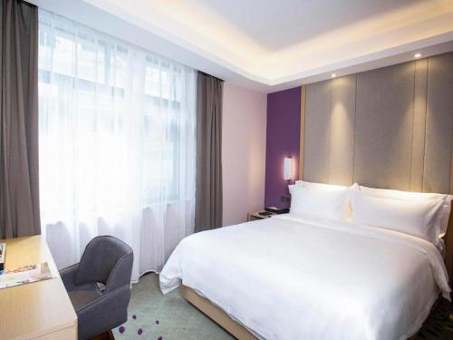 a hotel room with a large bed and a window at Lavande Hotel Jiande Xin'an River in Thousand Island Lake