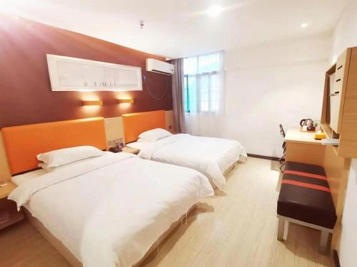 a hotel room with two beds and a desk at 7 Days Premium Hotel Ji'an Taihe Gongnongbing Avenue in Ji'an