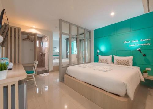a bedroom with a large bed with a green wall at Tiny Krabi Hotel in Ao Nang Beach