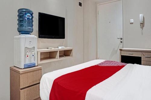 a hotel room with a bed with a red blanket at Capital O 91820 S&a Collection 2 in Jakarta