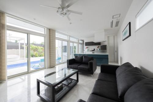 a living room with a couch and a glass table at LEO癒Resort宮古島 Pool & Villa in Miyako-jima