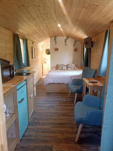 une petite pièce avec un lit, une table et des chaises dans l'établissement Les bois d'ormes, à Bessey-en-Chaume