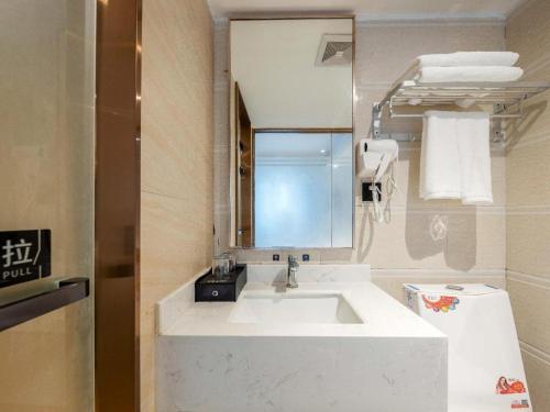 a bathroom with a white sink and a mirror at Yimi Hotel Guangzhou Yuexiu Park North Branch in Guangzhou