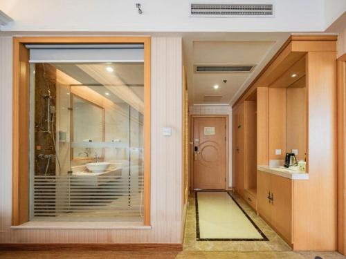 a bathroom with a glass door with a sink at Vienna Hotel Chengdu Xinfan Furniture City in Chengdu