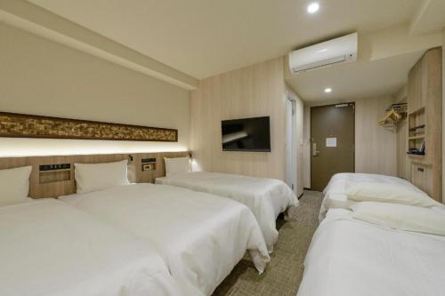 a hotel room with two beds and a tv at Hotel IL FIORE Kasai in Tokyo