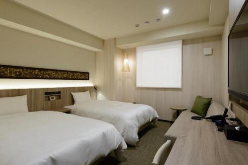a hotel room with two beds and a window at Hotel IL FIORE Kasai in Tokyo