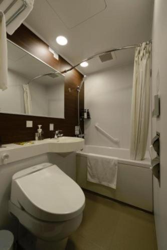 a bathroom with a toilet and a sink and a tub at Hotel IL FIORE Kasai in Tokyo